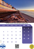 Calendar with a scenic view of a train passing through Dawlish, featuring a railway track and coastal houses.